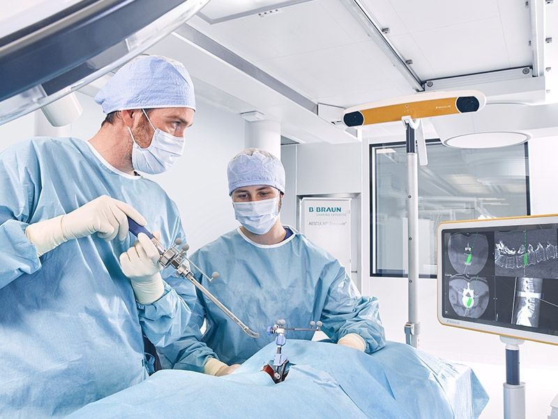 Dois cirurgiões durante um procedimento cirúrgico com dispositivos de fusão intercorporal 3D Ennovate®