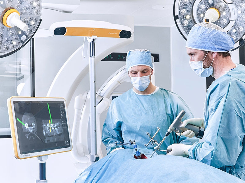 Dois cirurgiões durante um procedimento cirúrgico com Ennovate® Cervical MIS