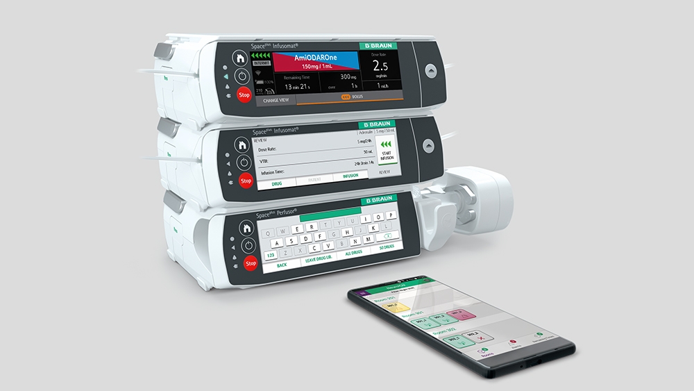 Sistema de infusão Space Plus e um smartphone em frente a ele com o aplicativo associado aberto. 