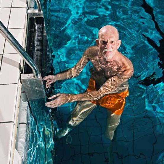 idoso na escada da piscina