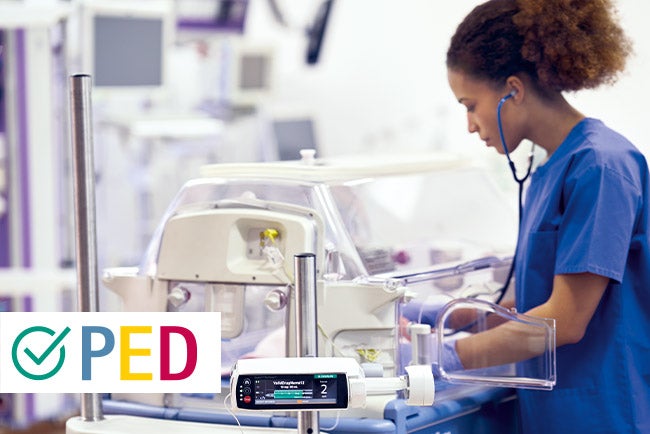 Enfermeira pediátrica em frente a uma incubadora na ala de neonatologia
