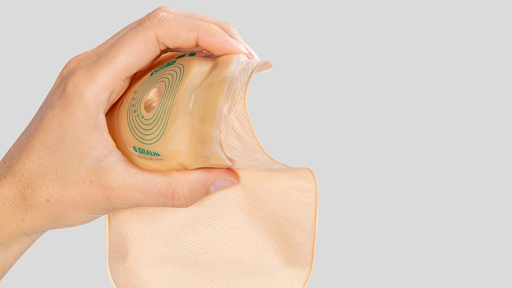 Mão segurando uma bolsa de estoma convexa