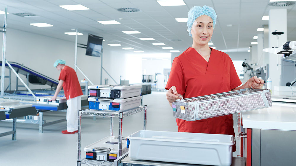 Dois trabalhadores segurando recipientes de metal em uma fábrica