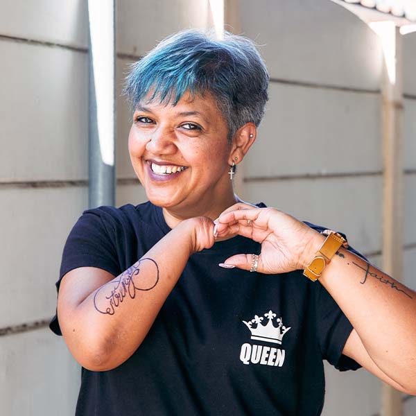 Renata Almeida, uma funcionária da Braun, de pé e sorridente em frente a uma TV que exibe gráficos em um escritório. 