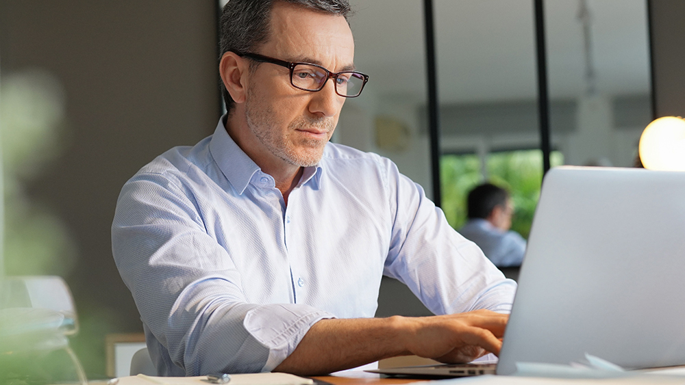 Homem digitando concentrado em um laptop