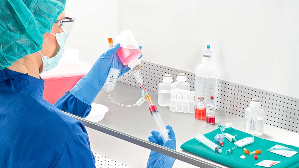 Farmacêutica prepara seringa sob fluxo de ar laminar