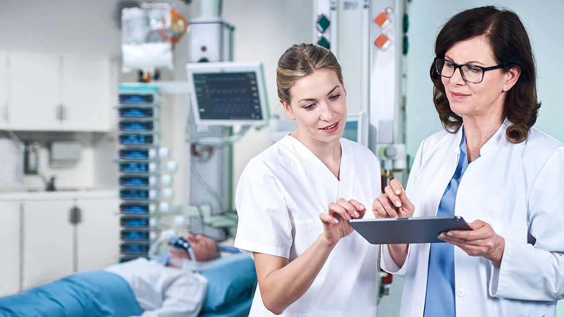 Dois profissionais médicos utilizam o gerenciamento inteligente de medicamentos através do iPad