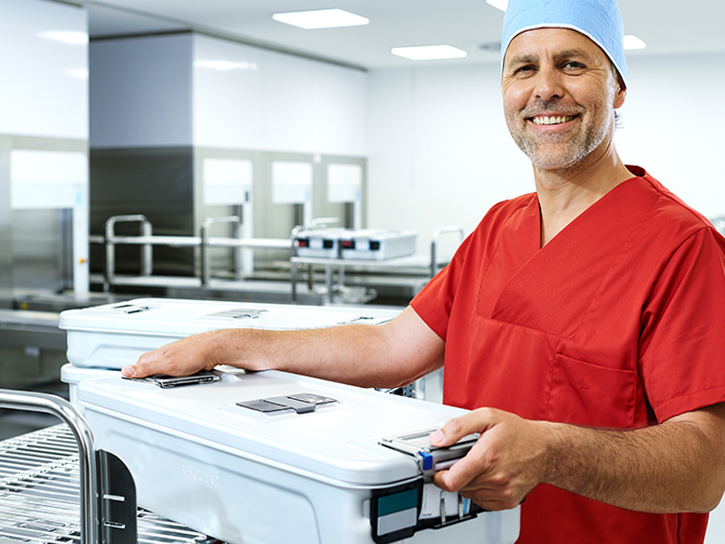 Funcionário do CSSD com um recipiente esterilizado nas mãos