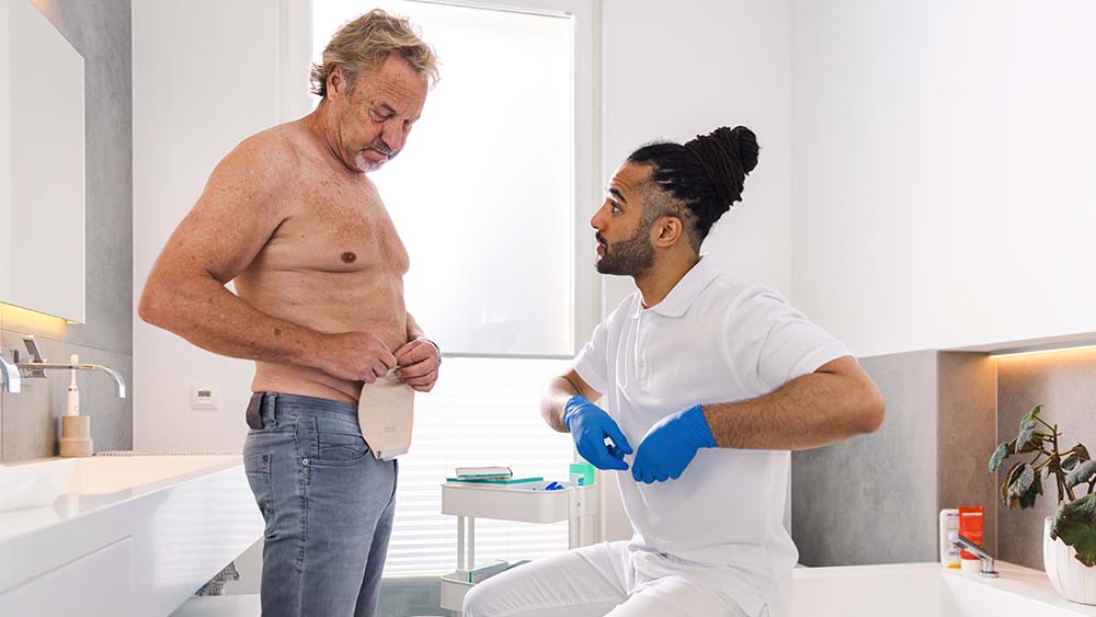 Um profissional médico mostrou a uma paciente como colocar uma bolsa de ostomia da B. Braun no conforto de sua própria casa.
