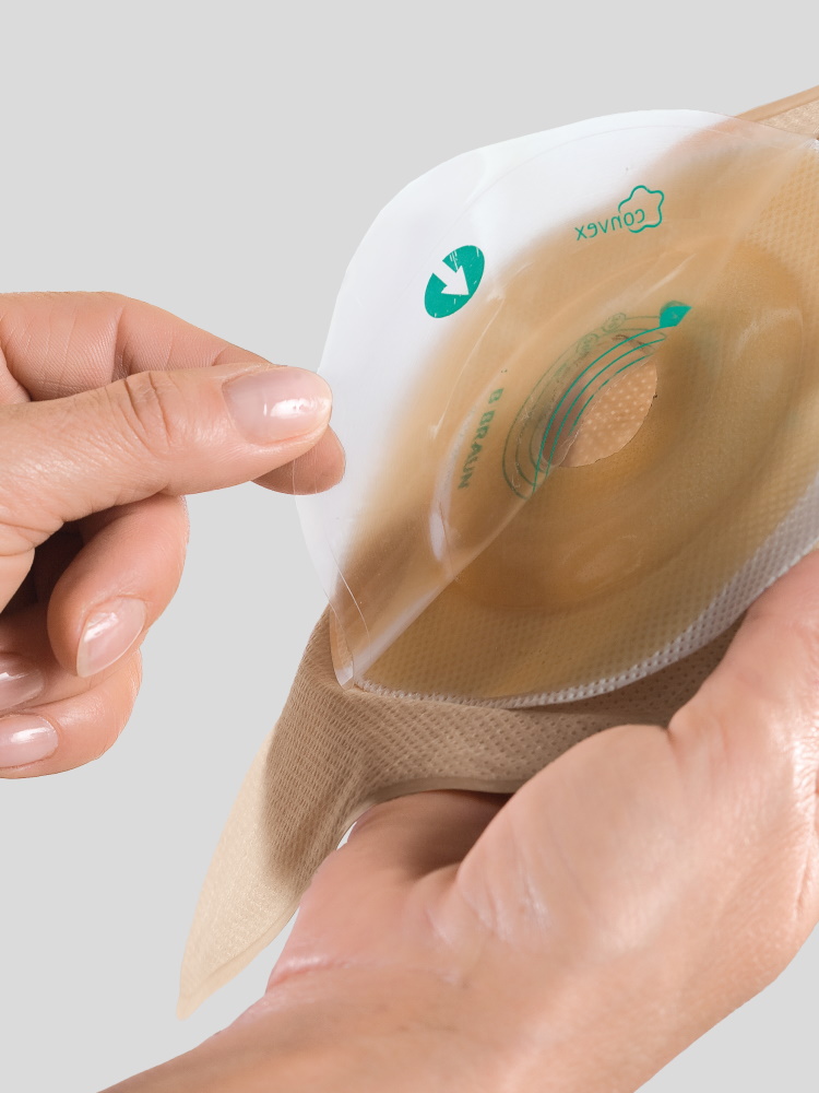 Duas mãos segurando uma bolsa de estoma com uma placa de formato convexo