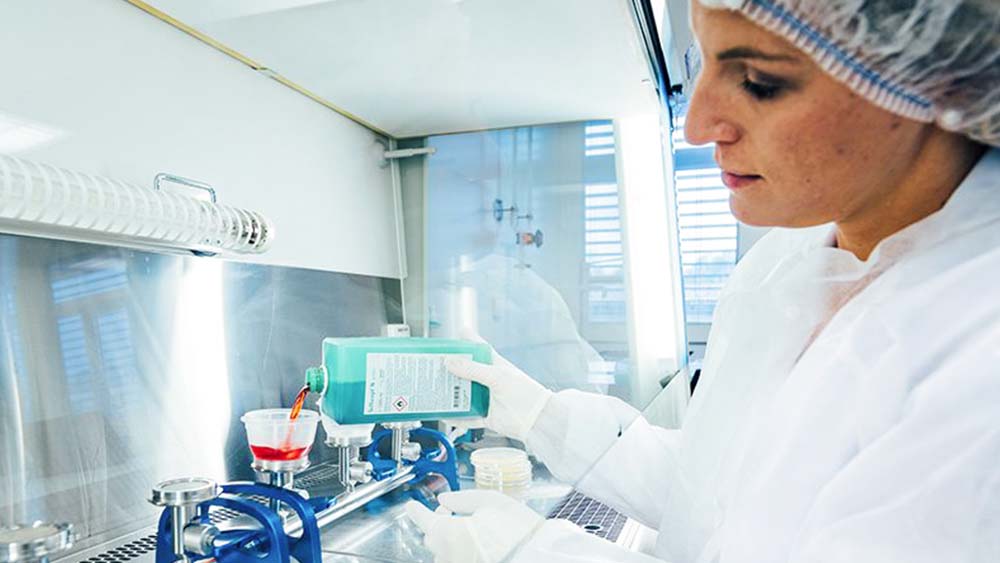 Um funcionário de laboratório enche um equipamento médico com desinfetante da B. Braun. 